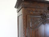 a wooden armoire with carvings on the top of it