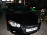 une voiture noire garée dans un garage à côté d'un vélo
