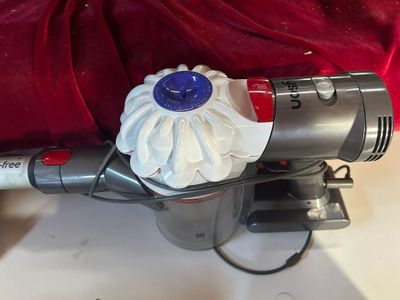 Quelqu'un utilise un aspirateur pour nettoyer le dessus d'une couverture rouge.