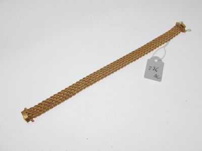 Gros plan sur un bracelet en or portant une étiquette