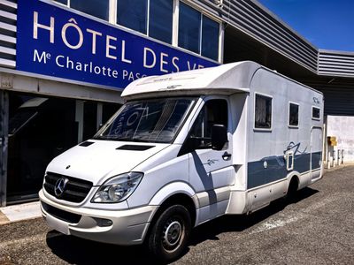 une camionnette blanche garée devant un hôtel