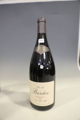une bouteille de vin posée sur un comptoir à côté d'un verre de vin