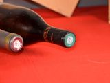 two bottles of wine sitting on a red table