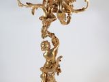 an image of a golden candelab with angels and flowers on it
