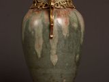 a green vase sitting on top of a wooden table