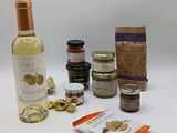 une bouteille de vin, un sachet de noix et un paquet de confitures