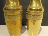 two gold vases sitting on a white table