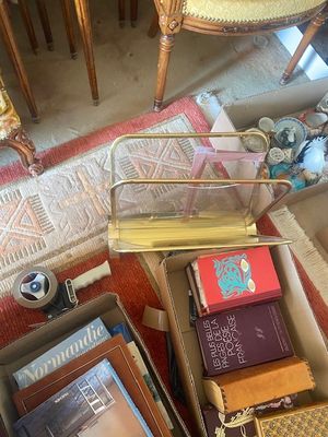 une boîte remplie de livres posée par terre à côté d'une chaise