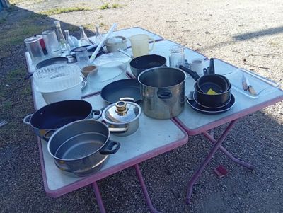 many pots and pans on a table outside