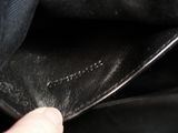 the inside of a black purse with a hand holding it