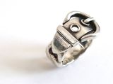 a silver ring with a buckle on it on a white surface