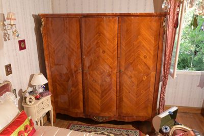 une chambre avec un lit, une commode et d'autres objets posés par terre