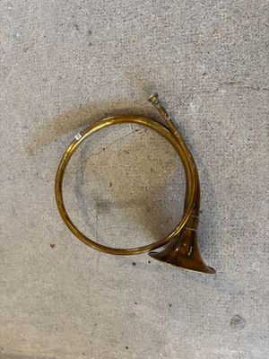 un petit instrument en laiton posé par terre près d'un mur