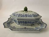 une image d'un plat bleu et blanc de type tureeny avec une feuille verte sur le dessus