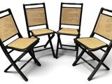 quatre chaises pliantes noires avec des assises en osier sur fond blanc