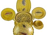 a lot of yellow dishes and bowls with fish on them
