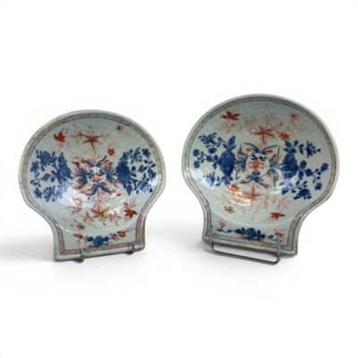 pair of blue and white plates with flowers on them on a stand