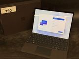 a laptop computer sitting on a table next to a box