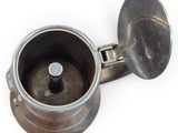 a silver coffee pot with a metal lid on a white surface