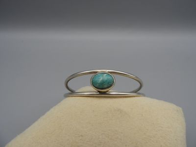 un gros plan d'une bague sertie d'une pierre de turquoise