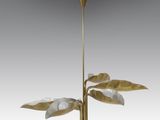 un lustre doré et blanc orné de feuilles suspendu au plafond