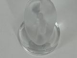 a clear glass object on a white surface
