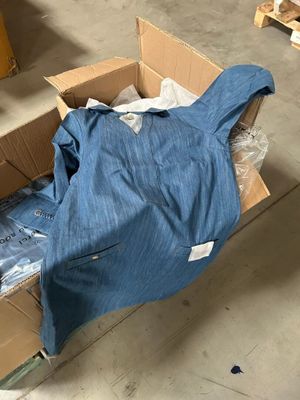une boîte contenant une chemise bleue, posée par terre
