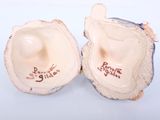 two pieces of pottery that are sitting on a table