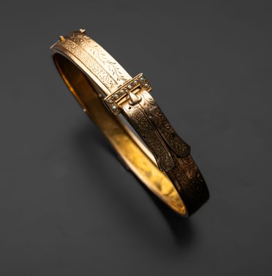 Gros plan sur un bracelet en or orné d'une croix