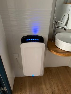 des toilettes blanches surmontées d'une lumière bleue, dans une salle de bains