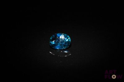 a close up of a blue diamond on a black surface