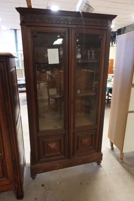 une grande armoire avec une porte vitrée au milieu d'une pièce