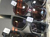 Plusieurs paires de lunettes de soleil sont exposées dans une vitrine.