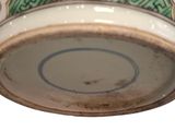 a close up of a bowl with a green and white design