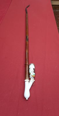 a long wooden stick with a bone on it on a red table