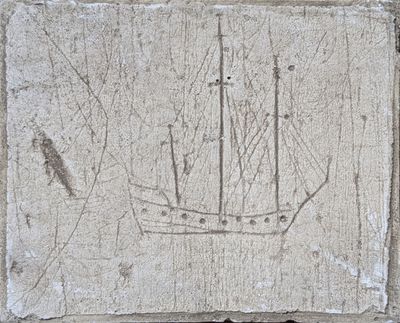 une plaque en pierre sur laquelle sont représentés un bateau et des oiseaux
