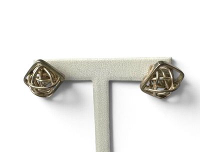 un gros plan sur une paire de boucles d'oreilles posées sur un présentoir blanc