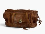 le sac en cuir marron est posé sur une surface blanche