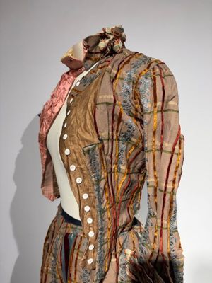 une photo d'une robe et d'une veste de femme exposées dans un musée