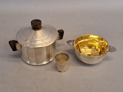 a silver pot and a silver cup next to each other