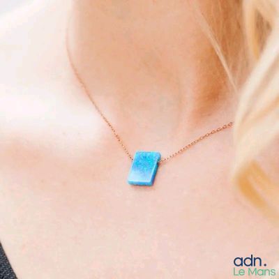 woman wearing a necklace that has a blue stone on it