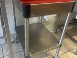 a red container sitting on top of a metal table