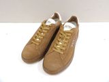 baskets marron avec des lacets jaunes sur un fond blanc