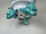 a white vase with blue birds on it on a table