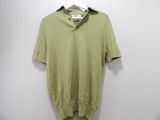 a green shirt hanging on a hanger against a white wall