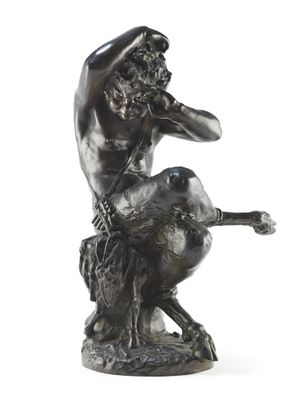 statue of a man sitting on a rock with a dog