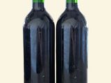 two bottles of wine sitting next to each other on a table