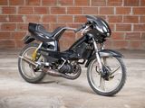 a black motorcycle parked in front of a brick wall