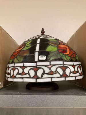une photo d'une lampe posée sur une table, à côté d'une boîte en carton