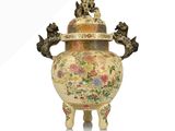 a vase that has a lion on it with flowers on it